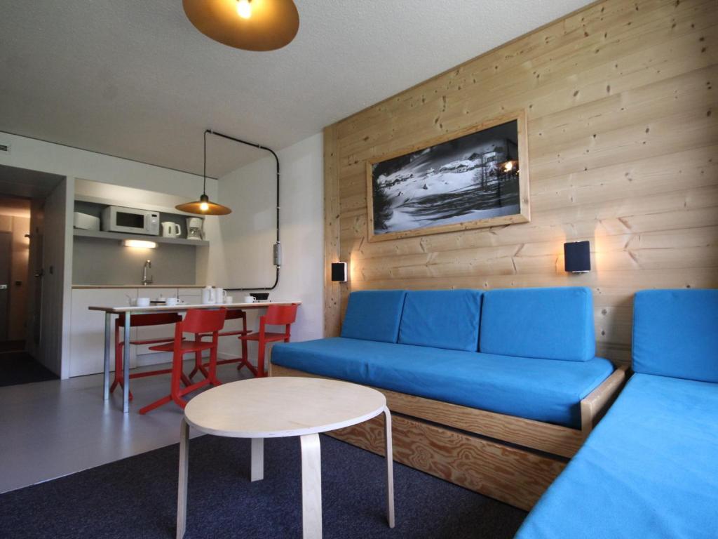 uma sala de estar com um sofá azul e uma mesa em Studio Les Arcs 1800, 1 pièce, 5 personnes - FR-1-346-366 em Arc 1800