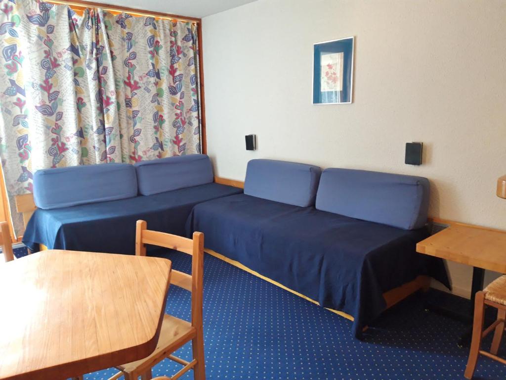 Cette chambre comprend un lit, une table et un canapé. dans l'établissement Studio lumineux au centre, balcon, proche pistes, wifi inclus - FR-1-346-420, à Arc 1800