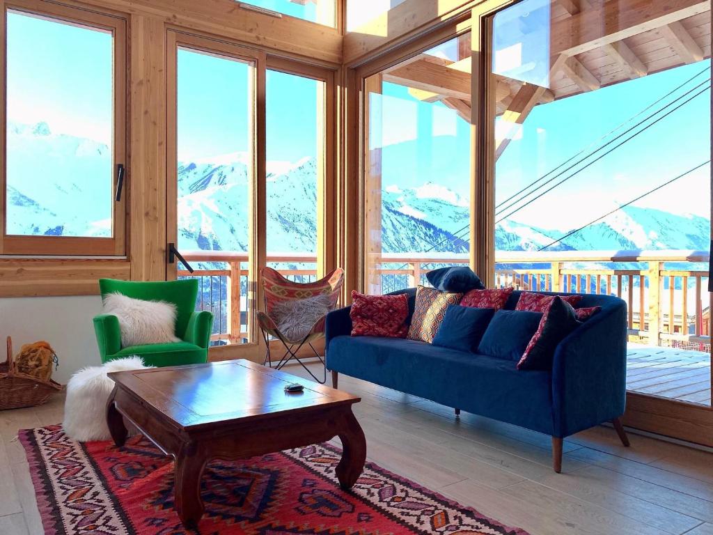 a living room with a blue couch and a table at Chalet Saint-Martin-de-Belleville, 5 pièces, 8 personnes - FR-1-344-759 in Saint-Martin-de-Belleville