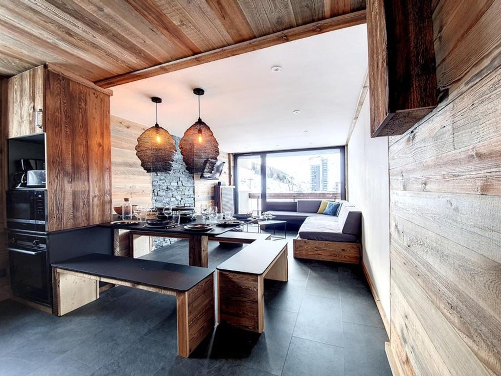 un salon avec une table et un canapé dans l'établissement Superbe appart rénové, balcon, au pied des pistes, style chalet, pour 8 pers - FR-1-344-735, aux Menuires