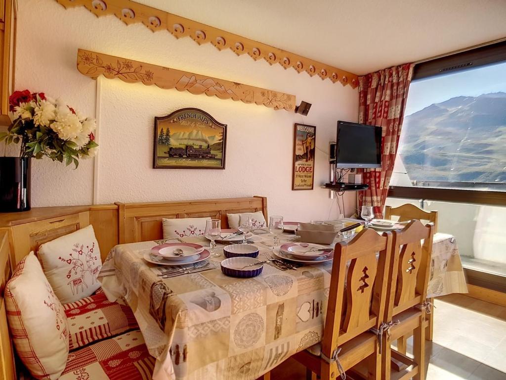 une salle à manger avec une table et de la vaisselle dans l'établissement Appartement duplex ensoleillé, skis aux pieds, balcon, 3 pièces, 8 pers., Les Menuires - FR-1-344-733, aux Menuires