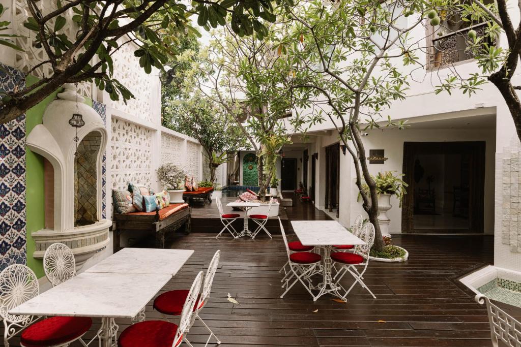 un patio esterno con tavoli, sedie e alberi di At Niman a Chiang Mai