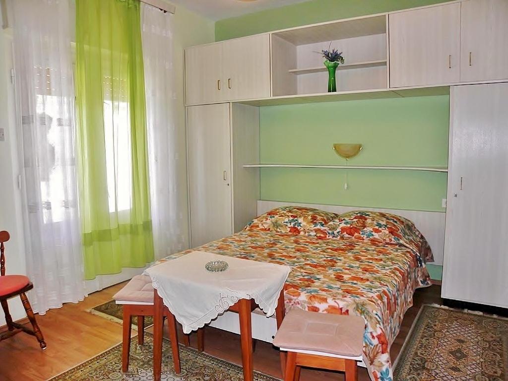 1 dormitorio con 1 cama y 1 mesa con en Alemka, en Banjol