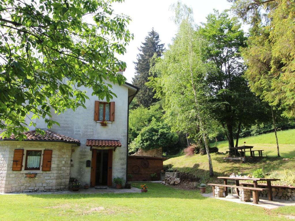 una casa con una mesa de picnic en el patio en Mountain-view holiday home in Cison di Valmarino with garden, en Cison di Valmarino