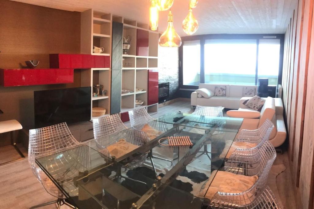 a living room with a glass table and chairs at Appartement "le chamois" la mongie centre 6 pers Bel appartement standing in La Mongie