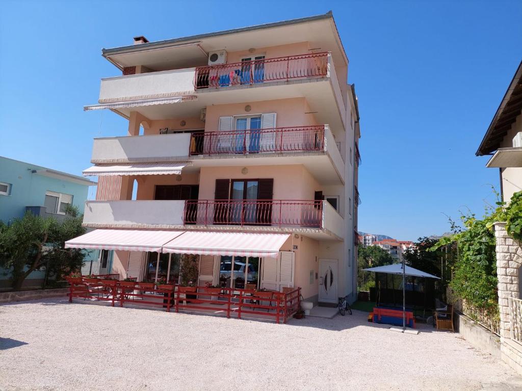 ein großes Gebäude mit Balkon und Sonnenschirm in der Unterkunft Apartment Antea in Split