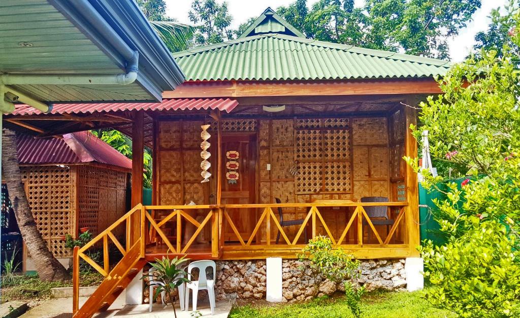 ein kleines Haus mit einer großen Holzterrasse in der Unterkunft MJ Room Rental Mahogany in Dauis