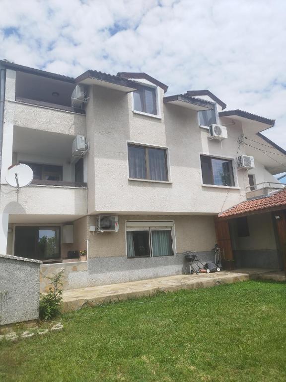 un gran edificio con ventanas y un patio verde en Вила Симеонов, en Varna