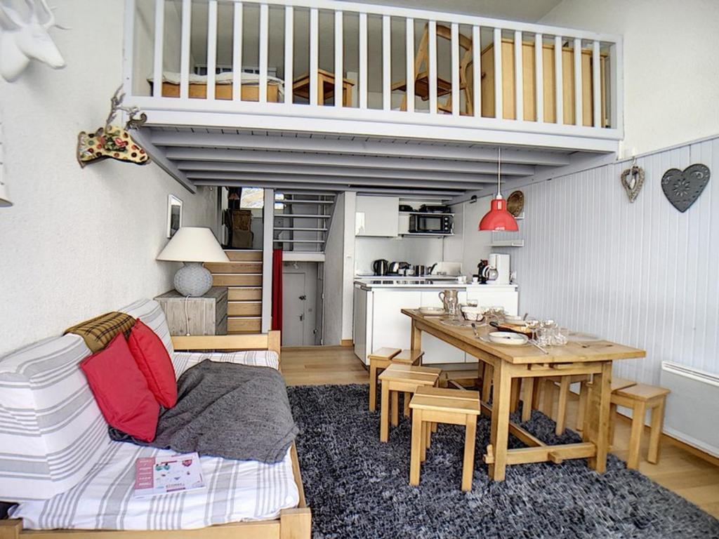 un salon avec une table et une cuisine dans l'établissement Duplex moderne avec balcon, ski aux pieds - FR-1-344-814, aux Menuires