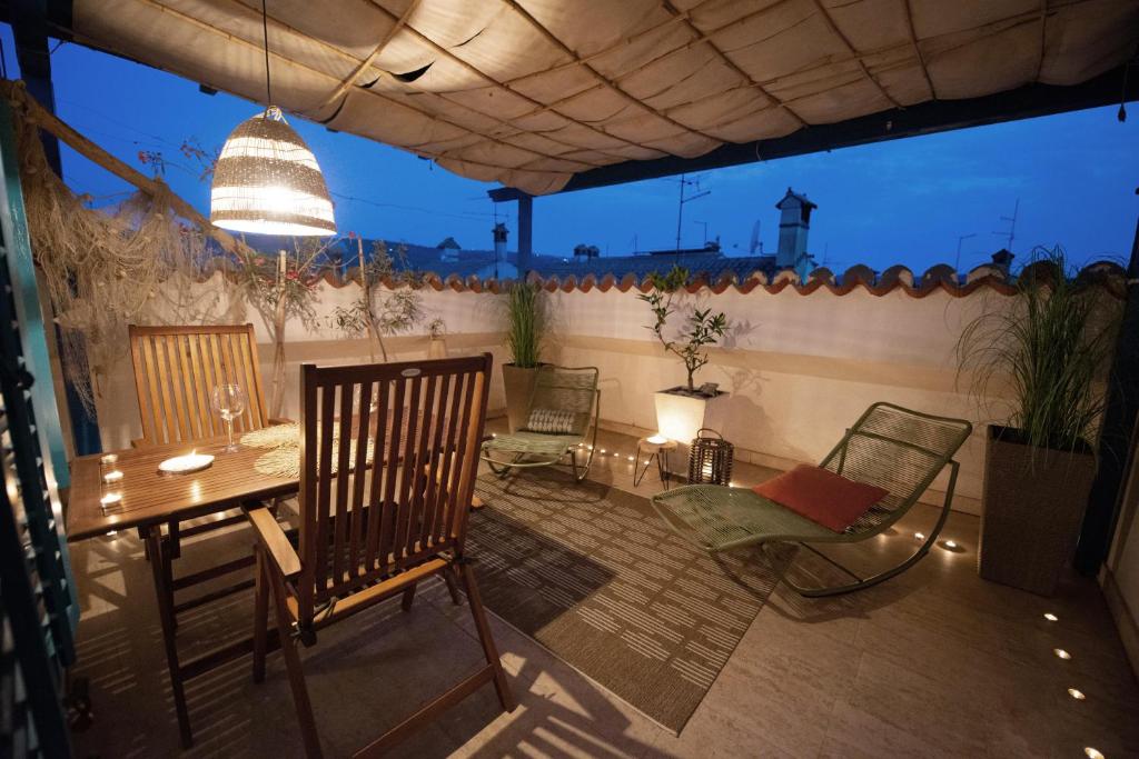un patio con sillas, una mesa, una mesa y un sillón en Modra Luna- apartment with terrace, en Izola