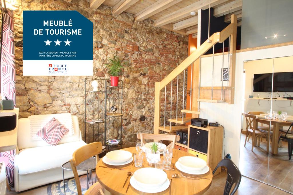 une salle à manger avec une table et un canapé dans l'établissement HOME SAVOIE - Le Cygne, à Annecy