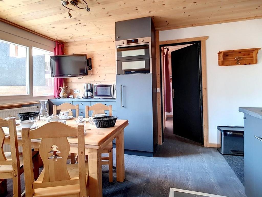 une cuisine avec une table en bois et un réfrigérateur dans l'établissement Appartement rénové · Départ et retour ski aux pieds · 6 pers · Quartier La Croisette - FR-1-344-847, aux Menuires
