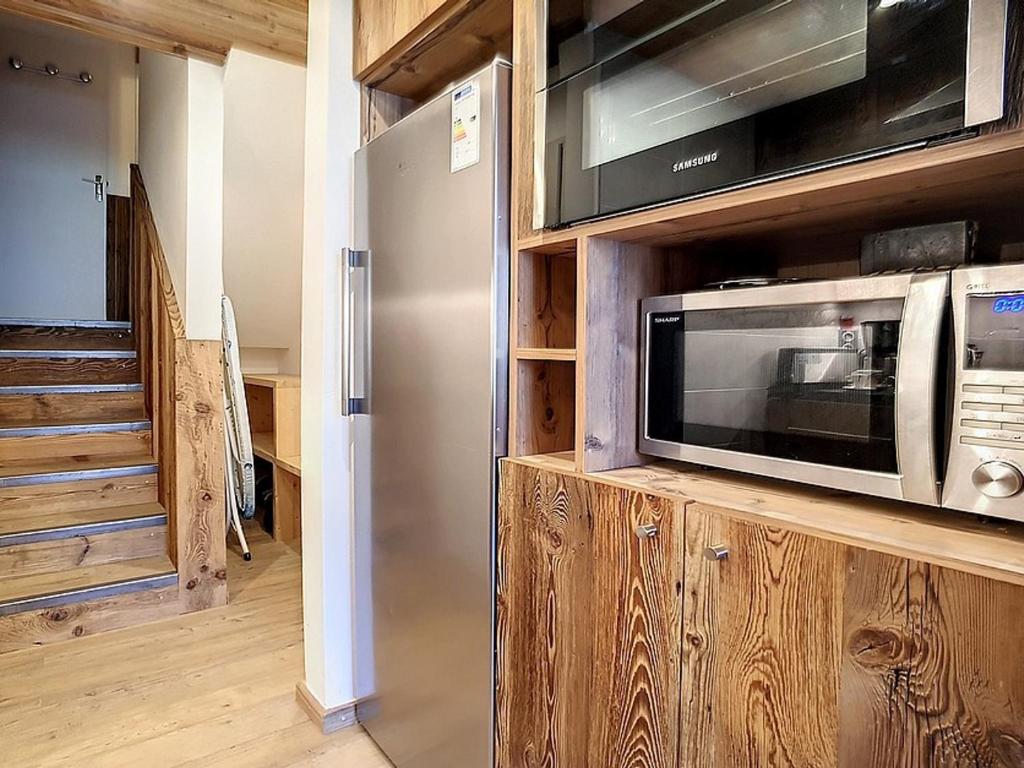 a kitchen with a microwave and a stainless steel refrigerator at Appartement Les Menuires, 2 pièces, 5 personnes - FR-1-344-855 in Les Menuires
