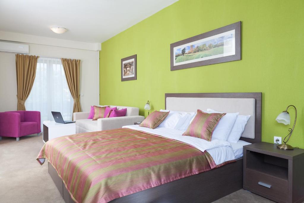 a bedroom with a large bed and a large window at Garni Hotel Ema in Kragujevac