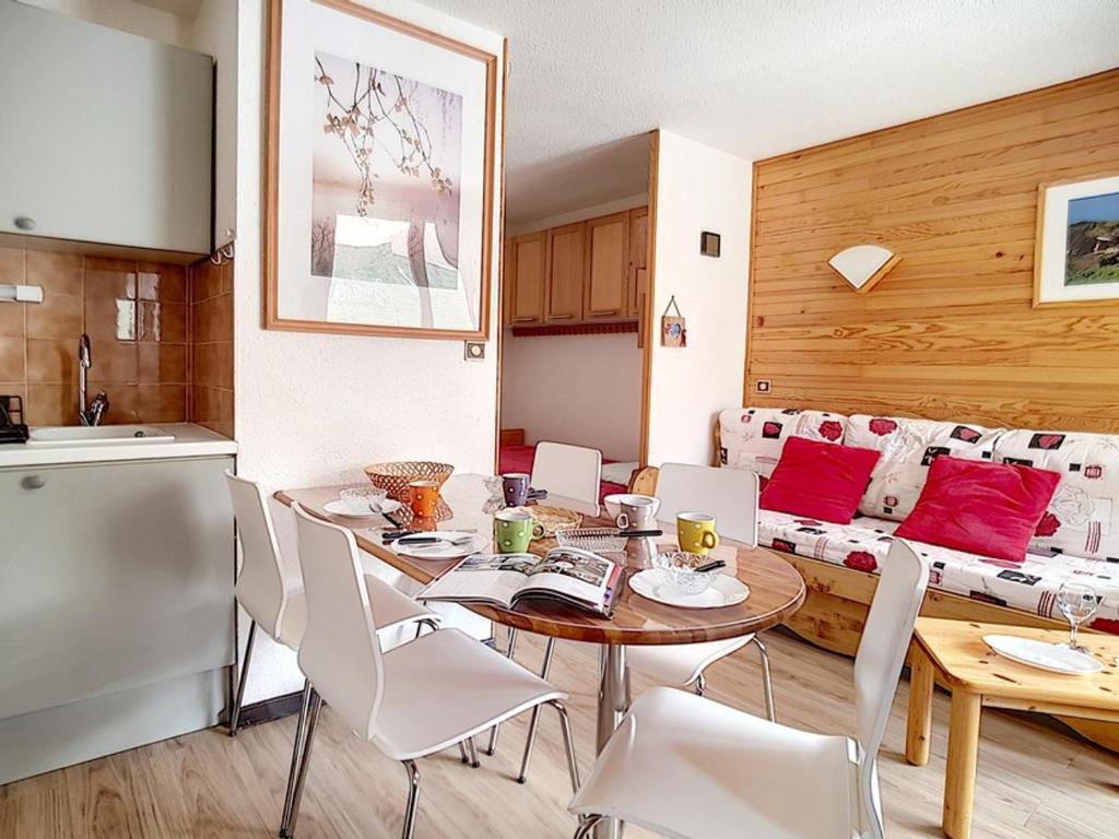 une cuisine et une salle à manger avec une table et des chaises dans l'établissement Appartement lumineux Départ ski aux pieds Terrasse - FR-1-344-912, aux Menuires
