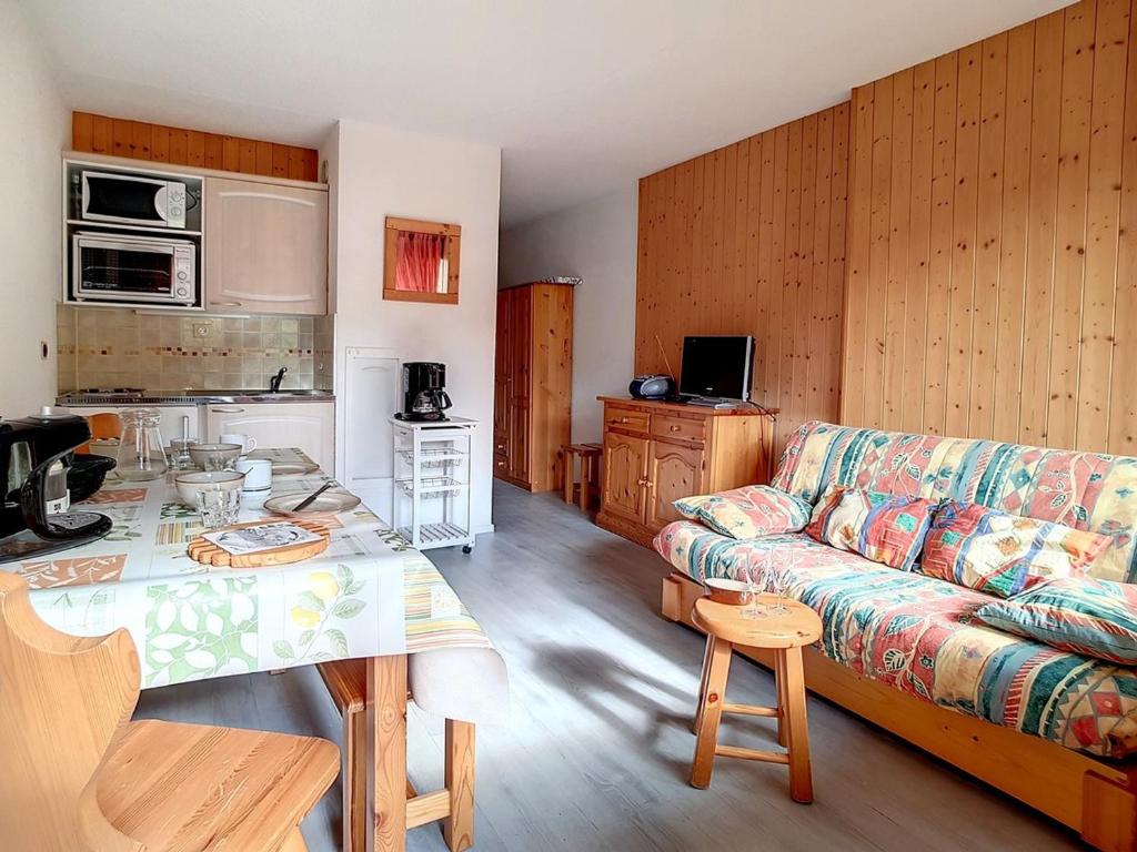 un salon avec un canapé et une table dans l'établissement Studio lumineux avec accès direct aux pistes et balcon - FR-1-344-917, aux Menuires