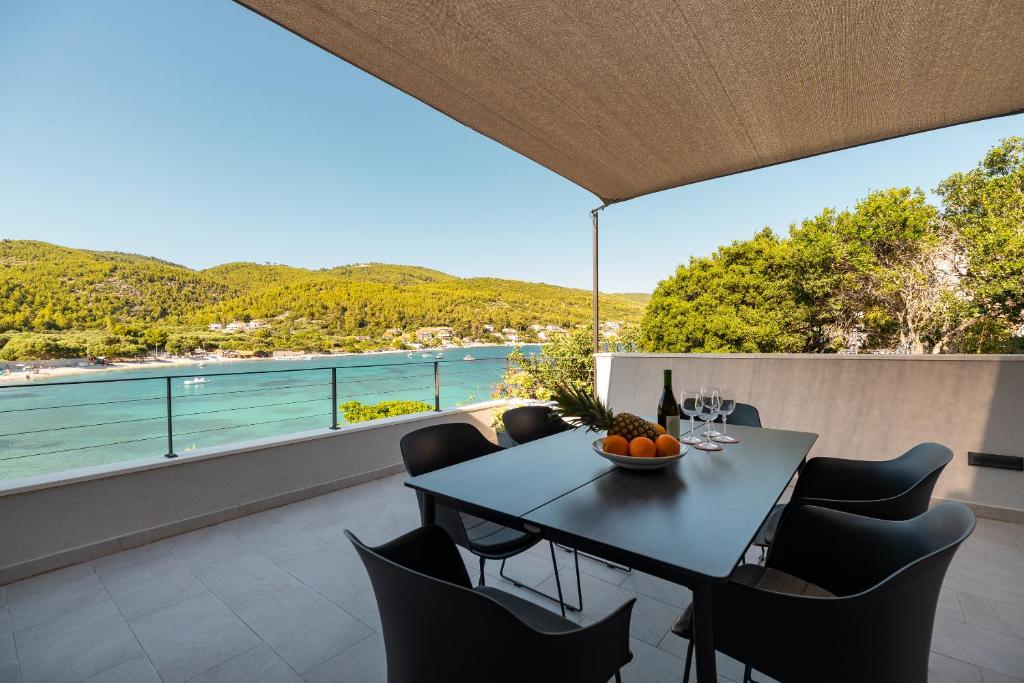 a table and chairs on a balcony with a view of the water at The Plaza Apartment in Prizba