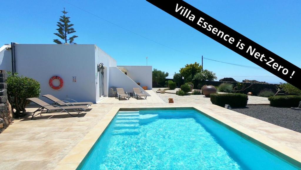 una piscina frente a una casa en Villa Essence - a unique detached villa with heated private pool, hottub, gardens, patios and stunning views!, en Tías