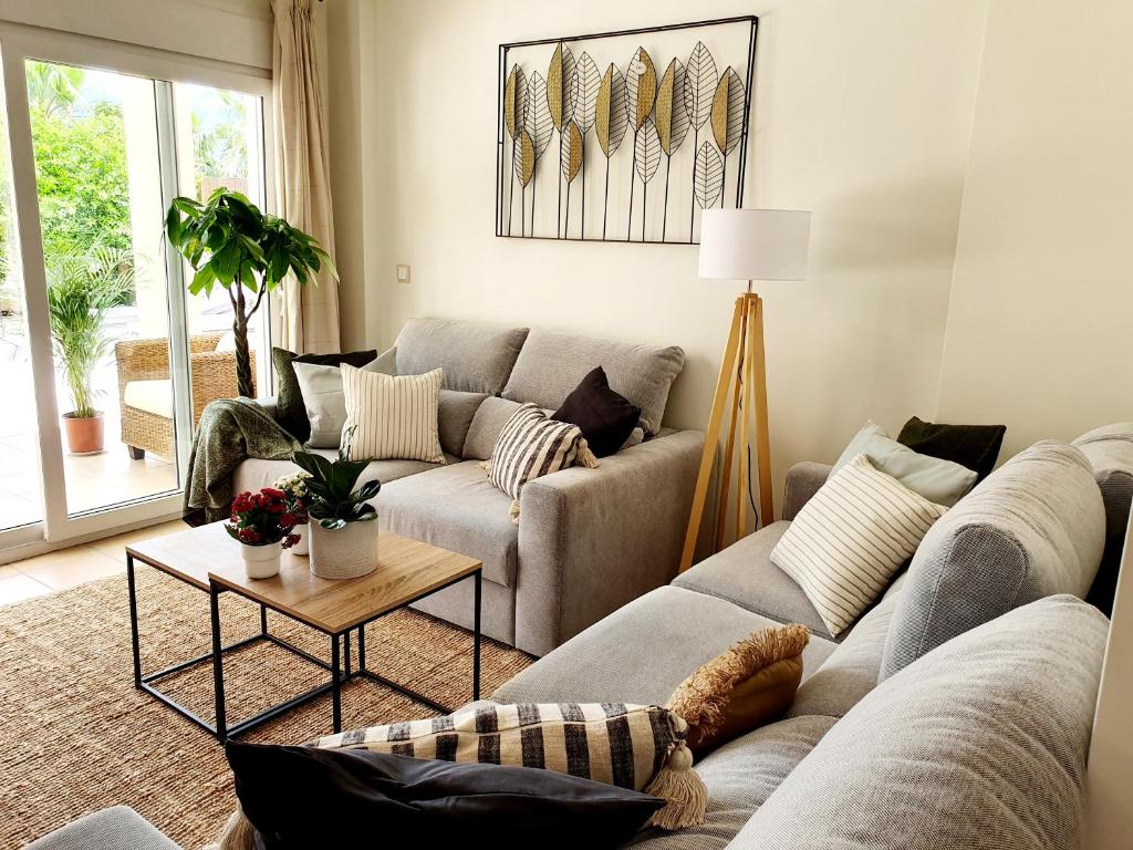 uma sala de estar com um sofá e uma mesa em Precioso Bajo gran terraza y piscinas Altaona Golf em Múrcia