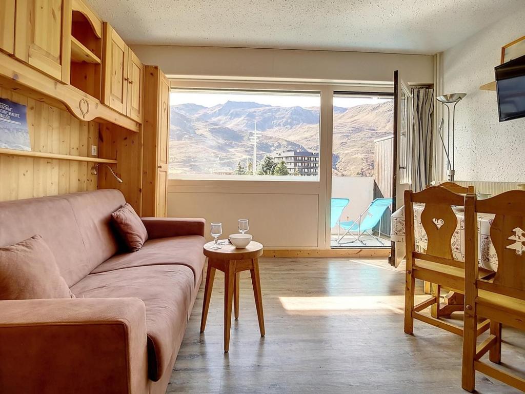 a living room with a couch and a large window at Studio Les Menuires, 1 pièce, 4 personnes - FR-1-344-953 in Les Menuires