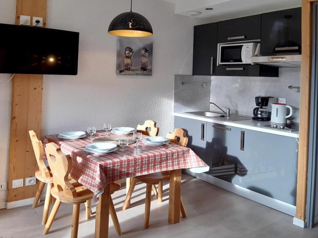 une cuisine avec une table et des chaises dans une pièce dans l'établissement Studio rénové avec balcon, proche des pistes, 3 pers, non fumeur - FR-1-344-933, aux Menuires