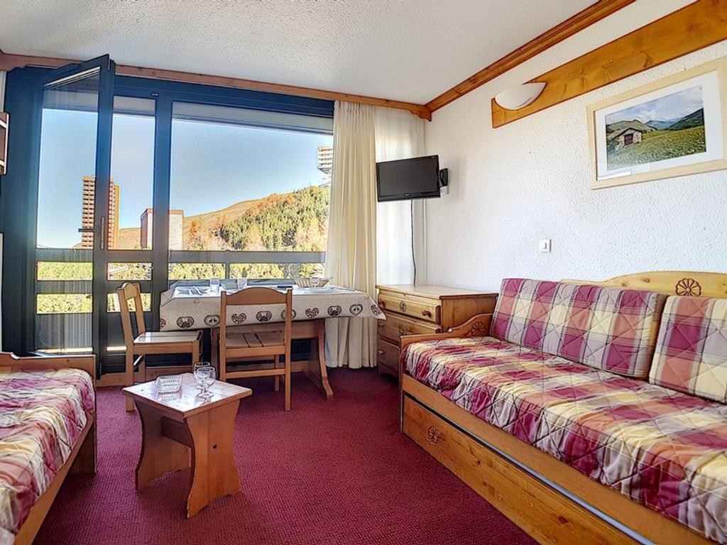 une chambre d'hôtel avec un canapé et une table avec vue dans l'établissement Studio 3 pers, ski aux pieds, balcon nord, TV, cuisine équipée, accès galerie marchande - FR-1-344-966, aux Menuires