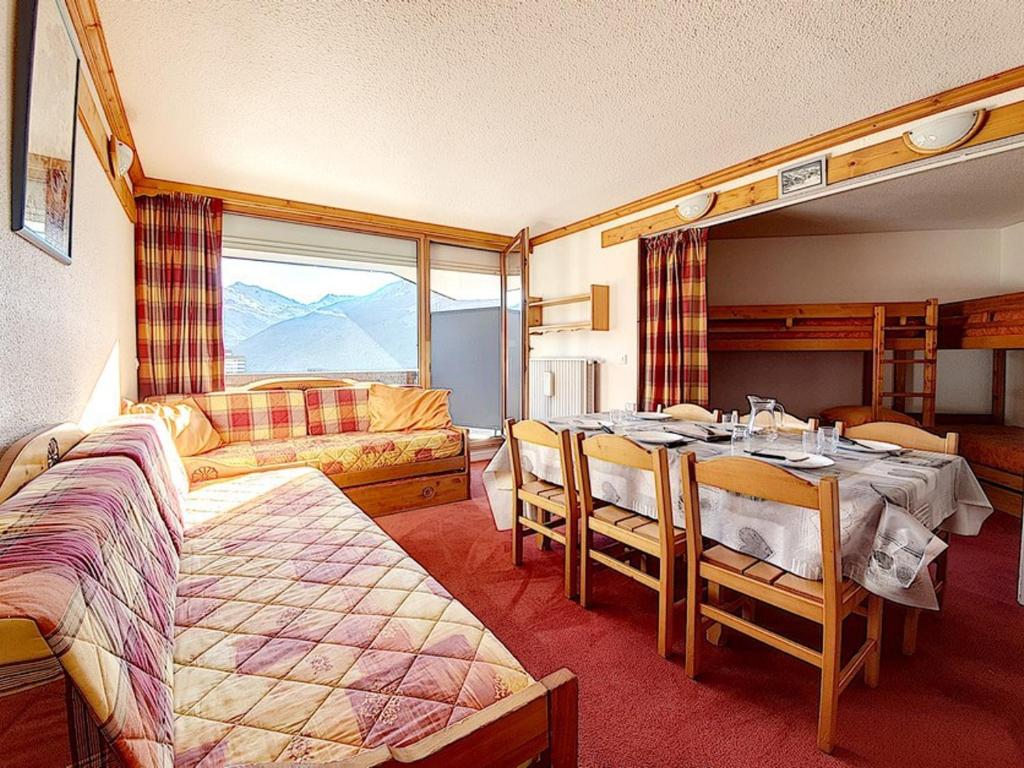 une chambre avec un lit et une table avec des chaises dans l'établissement Studio lumineux avec accès direct aux pistes, balcon sud et proche des commodités - FR-1-344-959, aux Menuires