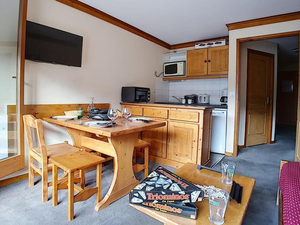 Il dispose d'une cuisine avec une table en bois et une cuisinière. dans l'établissement Appartement standard Départ ski aux pieds Balcon - FR-1-344-988, aux Bruyères