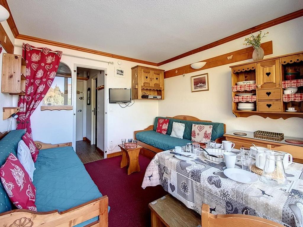 Cette caravane comprend un salon avec une table et un canapé. dans l'établissement Studio agréable Au pieds des pistes Balcon nord - FR-1-344-995, aux Menuires