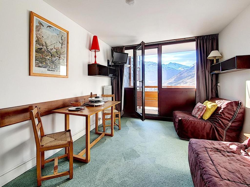 Cette chambre d'hôtel dispose d'un bureau et d'une table. dans l'établissement Studio fonctionnel au pied des pistes avec balcon - FR-1-344-989, aux Menuires