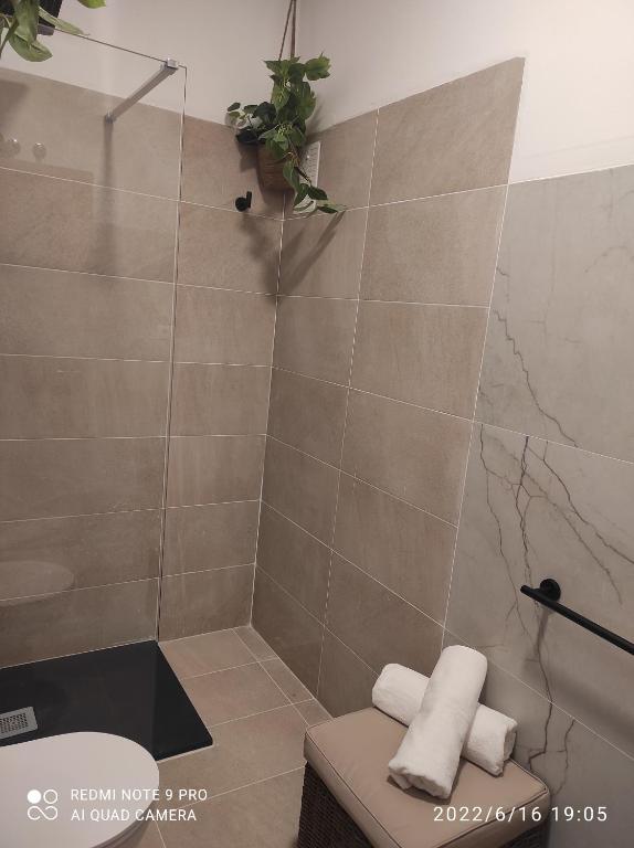 a bathroom with a shower with a toilet and towels at Suites 5* Lahcene in Alicante