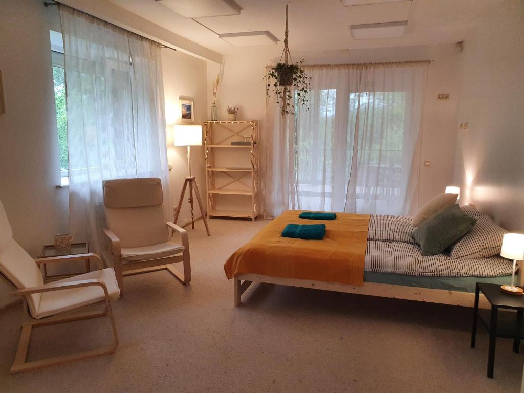 een slaapkamer met een groot bed en een stoel bij Surf Inn in Klaipėda