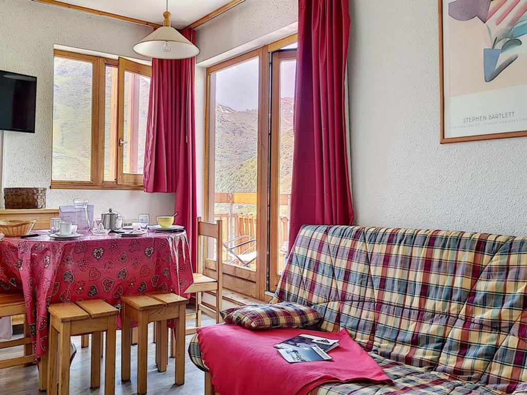 un salon avec une table et un canapé dans l'établissement Appartement cosy au pied des pistes avec balcon – 5 personnes, 32 m² - FR-1-344-1026, aux Menuires