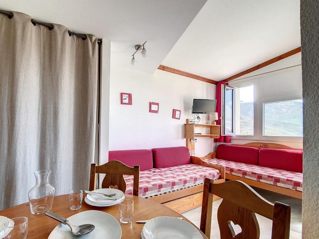 un salon avec un canapé rouge et une table dans l'établissement Studio lumineux Proche des pistes Balcon - FR-1-344-1035, aux Menuires
