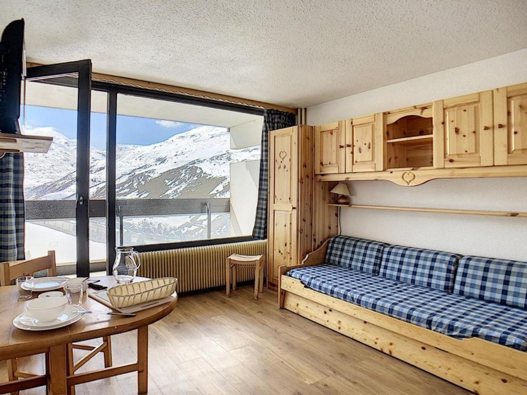 une chambre avec un lit, une table et une fenêtre dans l'établissement Studio lumineux Centre station Balcon - FR-1-344-1046, aux Menuires