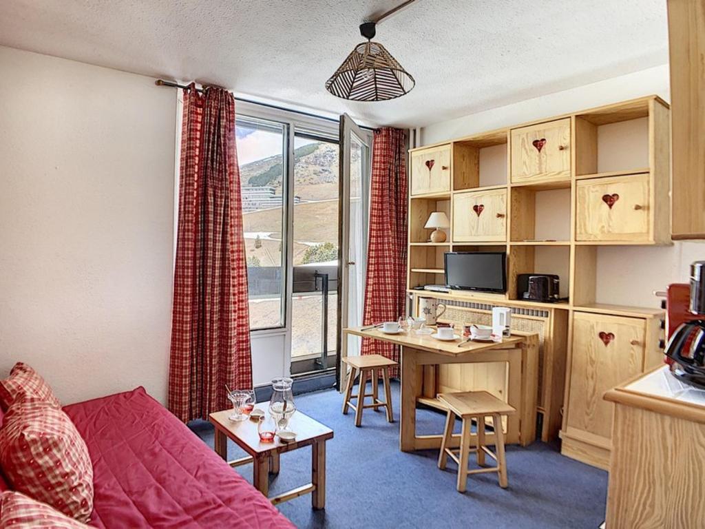 un salon avec un canapé rouge et une table dans l'établissement Studio cosy pour 2 au cœur de La Croisette, accès pistes à 150m - FR-1-344-1029, aux Menuires