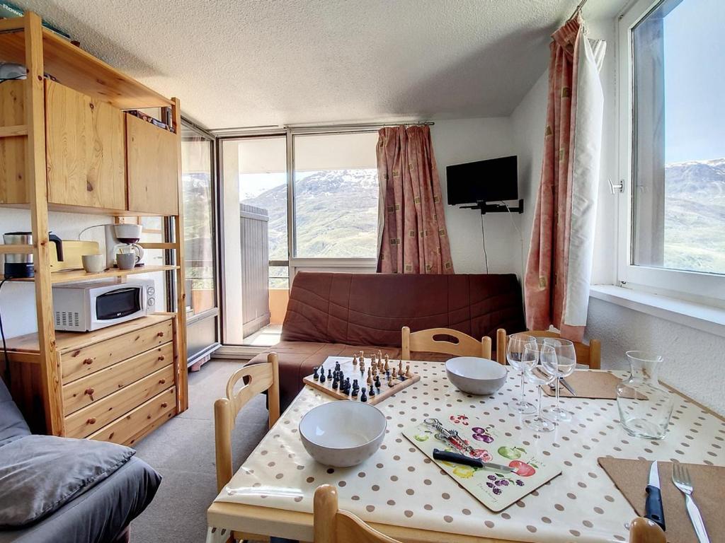 un salon avec une table et un canapé dans l'établissement Studio confortable proche des pistes avec balcon et cuisine équipée - FR-1-344-1043, aux Menuires