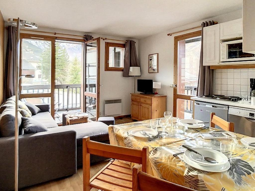a kitchen and living room with a table and a couch at Appartement cosy au pied des pistes avec parking et balcon, 4 pers, centre village - FR-1-344-1077 in Saint-Martin-de-Belleville