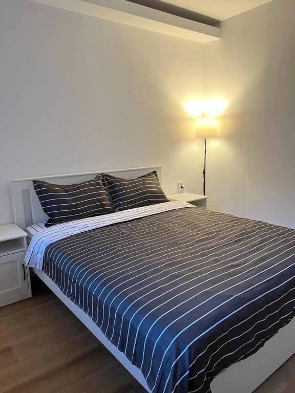 una camera da letto con un letto con un piumone a righe blu e bianche di Accommode a Sinaia