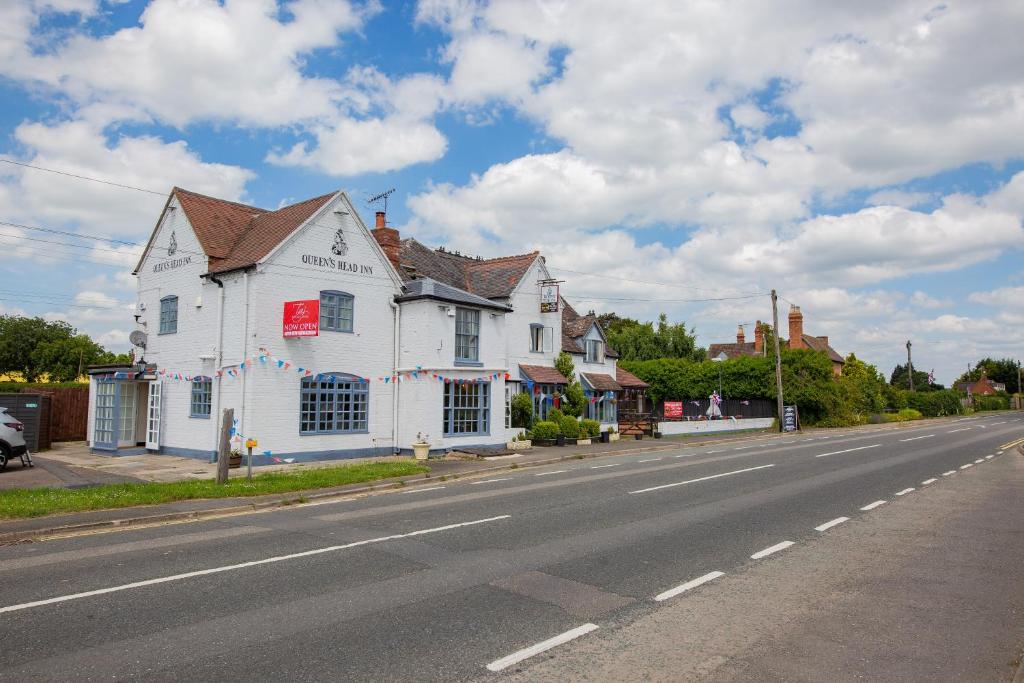 une maison blanche sur le côté d'une route dans l'établissement Queens Head Inn, à Evesham