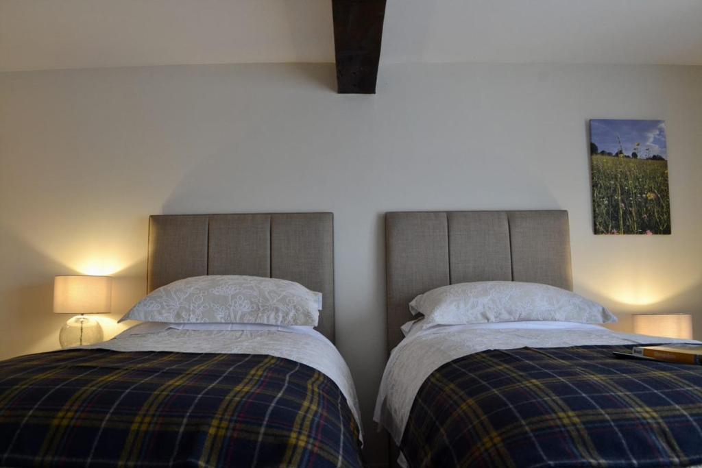 The Cedars Ludlow في Lane to Richards Castle: سريرين يجلسون بجانب بعض في غرفة النوم