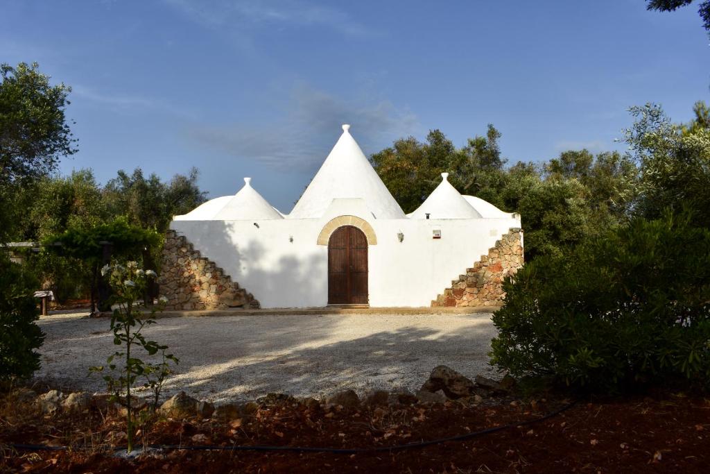 un bâtiment blanc avec une porte au milieu dans l'établissement Trulli Monte Madre, à San Vito dei Normanni