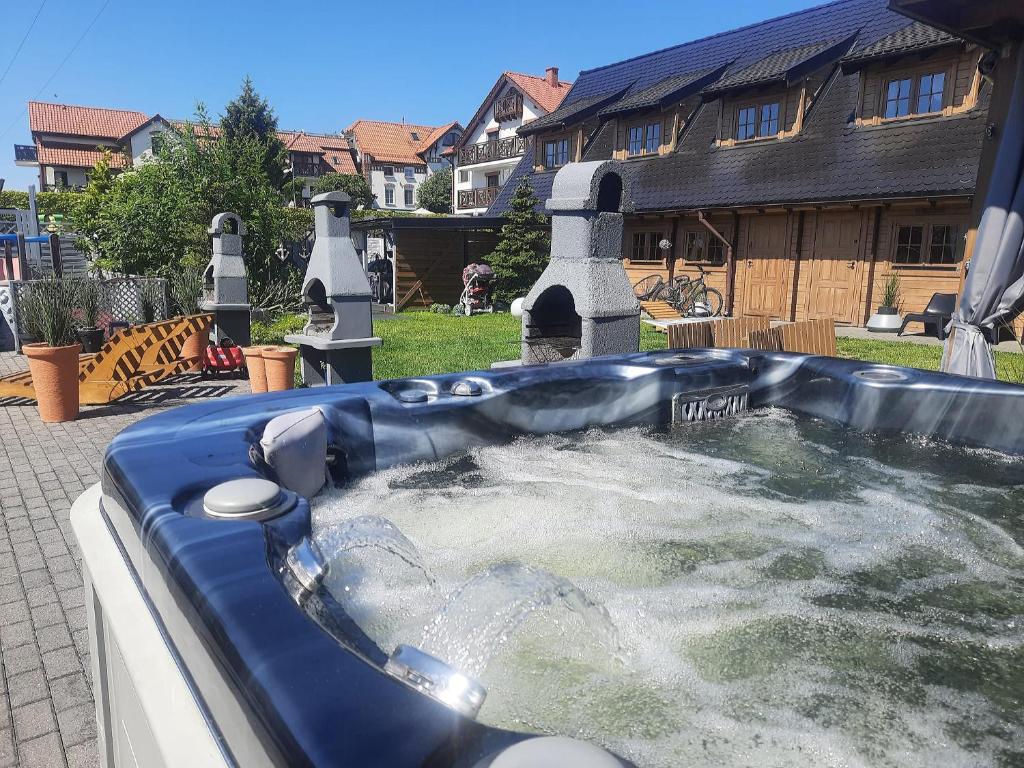 uma banheira de hidromassagem no quintal de uma casa em Domki Drewniane Całoroczne em Krynica Morska
