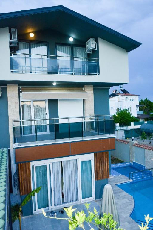 a house with a balcony and a swimming pool at BEGONVİL VİLLA in Belek