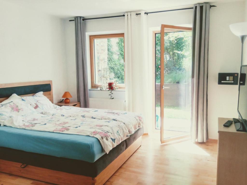 1 dormitorio con 1 cama y puerta corredera de cristal en Appartement Birgla, en Ramsau im Zillertal