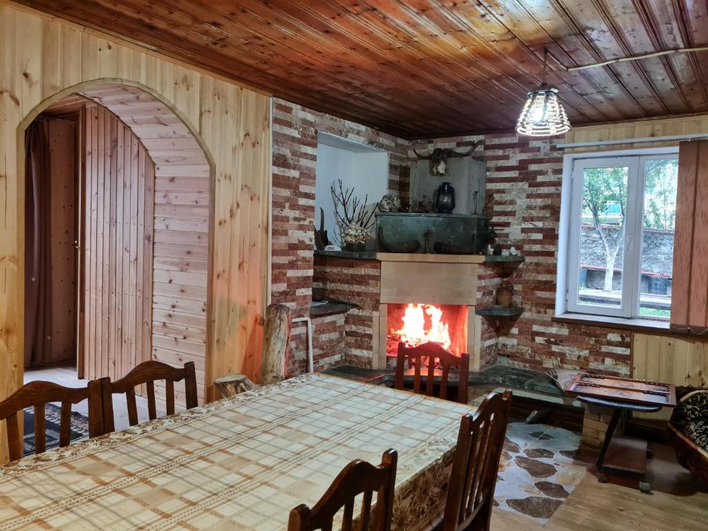 una sala da pranzo con camino, tavolo e sedie di Rusudani Family Guesthouse a Kazbegi