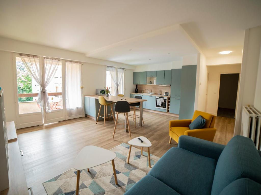 a living room with a blue couch and a table at appartement du Bellay in Sarlat-la-Canéda