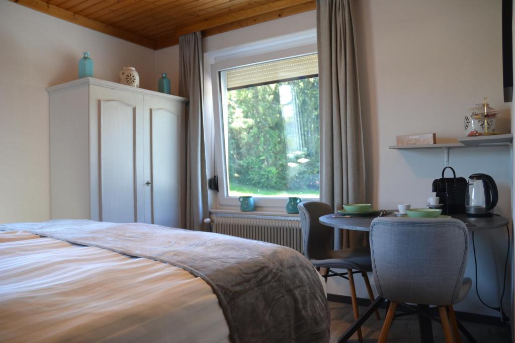 a bedroom with a bed and a table and a window at Nikolaierhaus in Feldkirchen in Kärnten