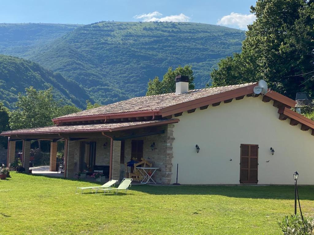 a white house with a mountain in the background at Meriggio Agriturismo in Fiastra
