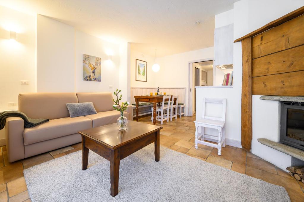 uma sala de estar com um sofá e uma mesa em Alpesmith - Bike & Ski apartments em Bardonecchia